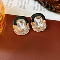 Detalle de pendientes ovalados vintage dorados con gota de aceite negro y cristal - Aguja de plata / Negro