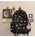 Detail von niedlichen Comic-Bärenprints auf schwarzem Rucksack mit rosa Plüsch-Blumenanhänger - Einzelne Tasche / Schwarzer Bär