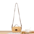 French vintage beige woven crossbody bag with brown leather strap and metal clasp on a table - Yellow