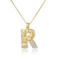 Macro shot of gold letter R pendant with cubic zirconia inlay on a thin box chain - Letter R