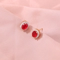 Detailed close-up of oval red gemstone earrings with white zircon halo in rose gold - SE816 Red Oval Zirconia