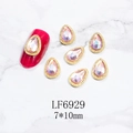 Detalle de diamantes de uñas de gota rosa 7x10mm con borde de metal dorado en mármol - Marco Dorado-Gota de Agua-Rosa AB(6929)
