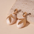 Macro view of water drop earrings with golden leaf pattern on pearlescent resin - Silver Needle - White Leaf Water Drop Earrings
