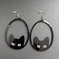 Detalle de los pendientes ovalados de acrílico con silueta de gato negro y ojos blancos - Gato negro