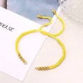 Adjustable bright yellow braided bracelet with golden beads and sliding knot closure - Yellow