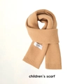 Detail of knitted beige children's scarf with stitched brand label on white background - Fine Knit Camel