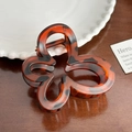 Minimalist butterfly hair claw clip in tortoiseshell resin on a rustic wooden desk - 7cm / Orange Red