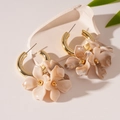 Macro di orecchini a cerchio dorati con petali in acrilico marmorizzato su pietra - Caffè Chiaro