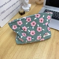Dettaglio beauty case in velluto a coste verde con motivi floreali e cerniera su tavolo in legno - Borsa Trucco in Velluto a Coste Fiori di Ciliegio