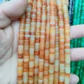 Close-up of natural stone spacer beads in orange and yellow hues for DIY jewelry - Red Aventurine