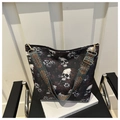 Detail of nylon bucket bag with skull print and wide vintage ethnic strap on a chair - Coffee