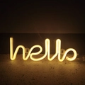 Detail of warm yellow LED hello neon sign mounted on a dark textured wall for decor - Warm White Hello Integrated