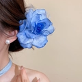 Große blaue Stoff-Netz-Rosen-Haarspange im Haar getragen für einen romantischen Look - Verlauf Rosen-Stil / Blau