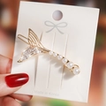 Close-up of golden fishtail hair clip with pavé rhinestones and gradient white pearls - White Rhinestone Mermaid Tail