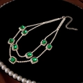 Detailed close-up of emerald green square gems and crystal rhinestones on a double necklace - Green Rhinestone Square Necklace