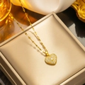 Collar de lujo de titanio con corazón de circonitas sobre un joyero de color beige - Corazón de Diamantes Dorado (8866)