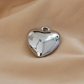 Mirror polished silver heart pendant with top loop shown on a beige silk background - 14# White K Heart 14
