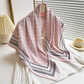 Pink silk scarf with geometric floral patterns and grey border on indoor background - Pink
