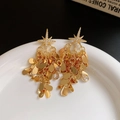 Détail de boucles d'oreilles pompons dorées avec motifs d'étoiles et oxydes de zirconium - Or (Tige en Argent S925)