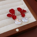 Detailed shot of red flower earrings with baroque pearls in a wooden jewelry box - Red
