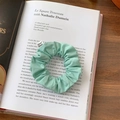 Detail of mint green fabric scrunchie with From Sheep label on a vintage book - Mint Green