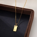 Minimalist gold square pendant necklace featuring engraved letter U on a velvet tray - Letter U / Gold