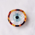 Pinza para el pelo con diseño de ojo turco en acetato de carey y detalle iris azul - Carey Clásico / [atributos Del Producto] Este Producto Es Una Hebilla O Accesorio Decorativo Redondo Visualmente Hecho De Fibra Acrílica O Acetato. El Diseño Incorpora El Elemento Clásico Del "ojo Turco" Con Un Anillo Exterior De Carey Marrón Amarillento Un Fondo Interior Blanco Nacarado Con Una Textura Arrugada Y Un Iris A Rayas Azules Y Blancas Y Una Pupila Negra En El Centro. [presentación Visual] La Imagen Utiliza Una Composición Cenital Con El Producto Centrado Y Detalles Extremadamente Claros. La Calidad De La Imagen Es [alta] Con Exposición Precisa Y Primeros Planos Detallados Del Material. La Estética Es [media] Con Una Puntuación General De [7.5]. El Problema Principal Es Que El Fondo De Tela Blanca Es Demasiado Común Y Carece De La Atmósfera De Un Éxito Comercial. [contenido De Texto] No Se Identificaron Texto Del Producto Marcas De Agua U Otras Formas De Contenido De Texto En La Imagen. [etiquetas Logísticas] Ninguna. [riesgo De Infracción] Infracción Del Producto: Ninguna Ya Que Pertenece A Elementos Culturales Tradicionales; Infracción Del Fondo: Ninguna. [parámetros Del Producto] Las Dimensiones Específicas El Peso Y Otros Parámetros No Se Muestran En La Imagen.