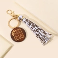 Close-up of wooden MAMA pendant with floral engraving and leopard print tassel keychain - White & Coffee Leopard