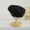 Detalle de gorra newsboy negra con hebilla lateral y etiqueta bordada de marca BRUNT - 52-54cm (3-8 Años) / Etiqueta BRU - Negro