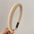 Close-up of beige padded sponge headband featuring a woven texture and handmade tag - Khaki