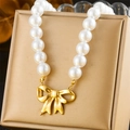 Macro view of imitation pearl necklace featuring a detailed golden bow pendant and clasp - Bowknot Necklace (N2852)