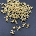 Detailweergave van talrijke gouden zeesterhangers op een donkere achtergrond - Zeester / 50 Stuks/Verpakking