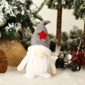 Gnomo de Navidad de felpa con gorro gris y estrella roja sobre fondo de nieve - Sombrero Gris con Estrella