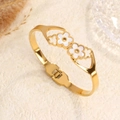 Elegant gold stainless steel open bangle featuring two white shell clover flower charms - Gold