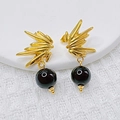 Orecchini a forma di uccello dorato con pendente di perla nera su tessuto bianco strutturato - Stile Perla Nera Ali / Perline Nere