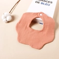 Detail van perzikkleurige hydrofiele baby slab met schulprand en witte drukknoop - Oudroze