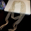 Dettaglio della collana a maglia dorata con cristalli azzurri e lunghe frange eleganti - Collana - Oro - Blu