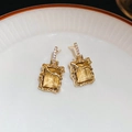 Detail of vintage gold-tone earrings with square yellow gemstone in textured branch frame - Gold