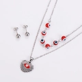Close-up of heart-shaped evil eye pendant and matching stud earrings jewelry set - Silver (Red Eye)