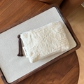 Detail einer weißen Baumwolltasche mit floraler Spitzenstickerei und Quasten-Reißverschluss - Münzbeutel