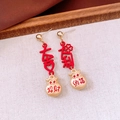 Detail of Chinese style tassel earrings with red lucky bag pendants and gold accents - Silver Pin - Gold - Fortune Bag