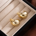 Minimalist golden bean stud earrings with polished finish in a beige jewelry box - Gold Half Moon