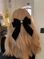 Detail of vintage black velvet bow hair clip with pearl on blonde wavy hair - Pearl Streamer
