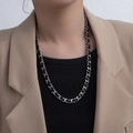 Collar de cadena plateada con cuero negro trenzado sobre traje formal de negocios - Collar