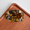 Detail of tortoiseshell acetate hair claw clip with hollow arch on a wooden tray - Round Claw / Tortoise