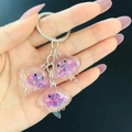 Detailed close-up of pink translucent jellyfish keychains with glitter and gold foil - Purple