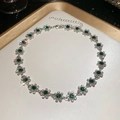 Detailed shot of silver flower pendant necklace with green gemstones and shiny crystals - Necklace - Silver - Green
