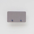 Close-up of small sapphire blue round-cut stud earrings in a six-prong silver setting - September: Sapphire Blue