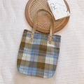 Detalle de bolso tote vintage de lona a cuadros con asas de cuero sobre una bandeja - Cuadros Gingham Azul Cepillado