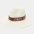 Detailed close-up of ethnic embroidered leather band and turquoise stud on straw hat - One Size / Ivory